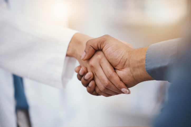 Bone-Crushing Handshake Indicates Health Despite Excess Weight Doctor, patient and handshake in hospital thank you, welcome or greeting for medicine trust, help or medical consulting. Zoom, black man and shaking hands with pharmacy worker or healthcare employee