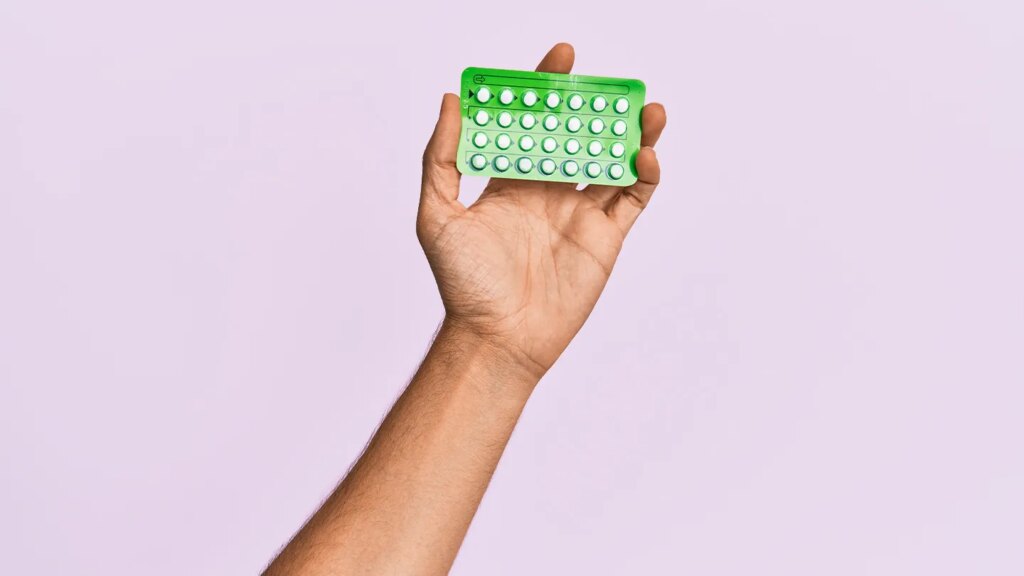 woman holding up contraceptive birth control pills