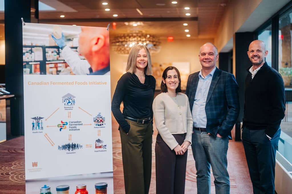 Canada’s Fermented Foods Initiative Hosts Inaugural Workshop: A Cross-Sector Conversation Begins Four people standing in a conference hall in front of a placard about the Canadian Fermented Foods Initiative