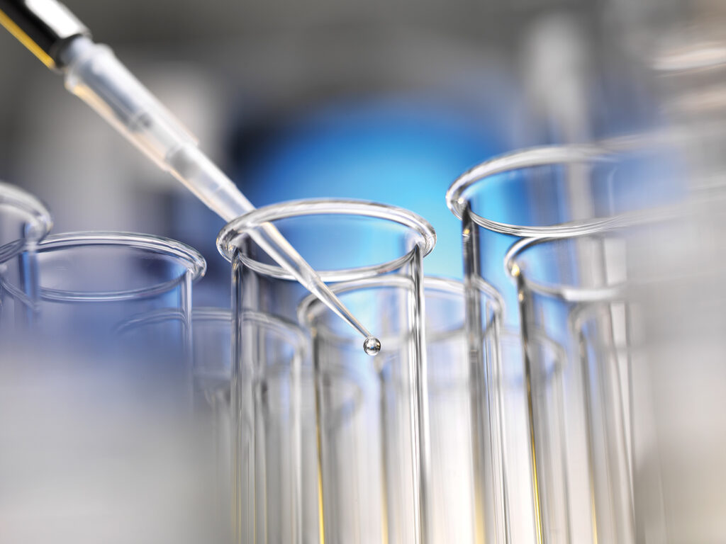 Scientist pipetting a sample into a test tube during a experiment in the lab