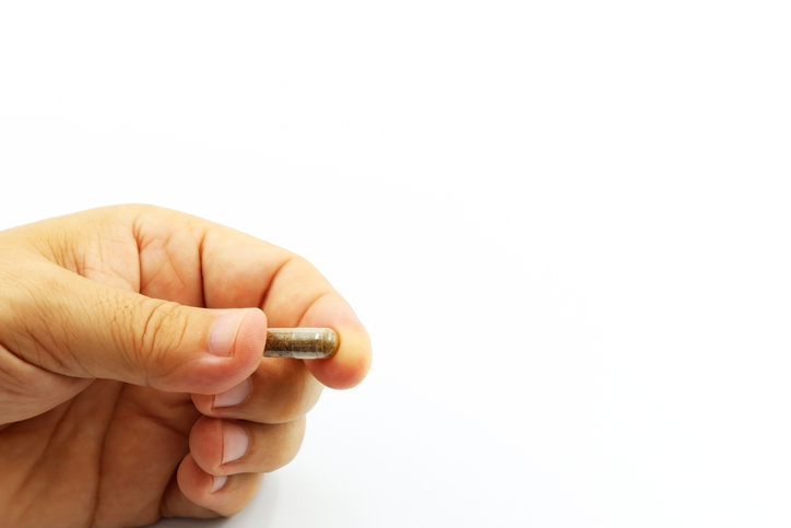 Computers Herald Era of Designer Probiotics Hand holding a capsule with microbiota, probiotics or lyophilized microorganisms for fecal microbiota transplantation (FMT).